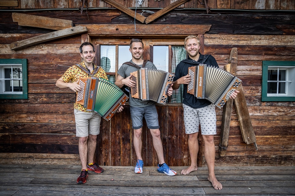 Drei Harmonikalehrer halten jeweils eine Steirische Harmonika