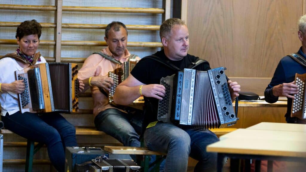 Vier Harmonikaspieler, die einem Vortrag über Talent aufmerksam und konzentriert zuhören