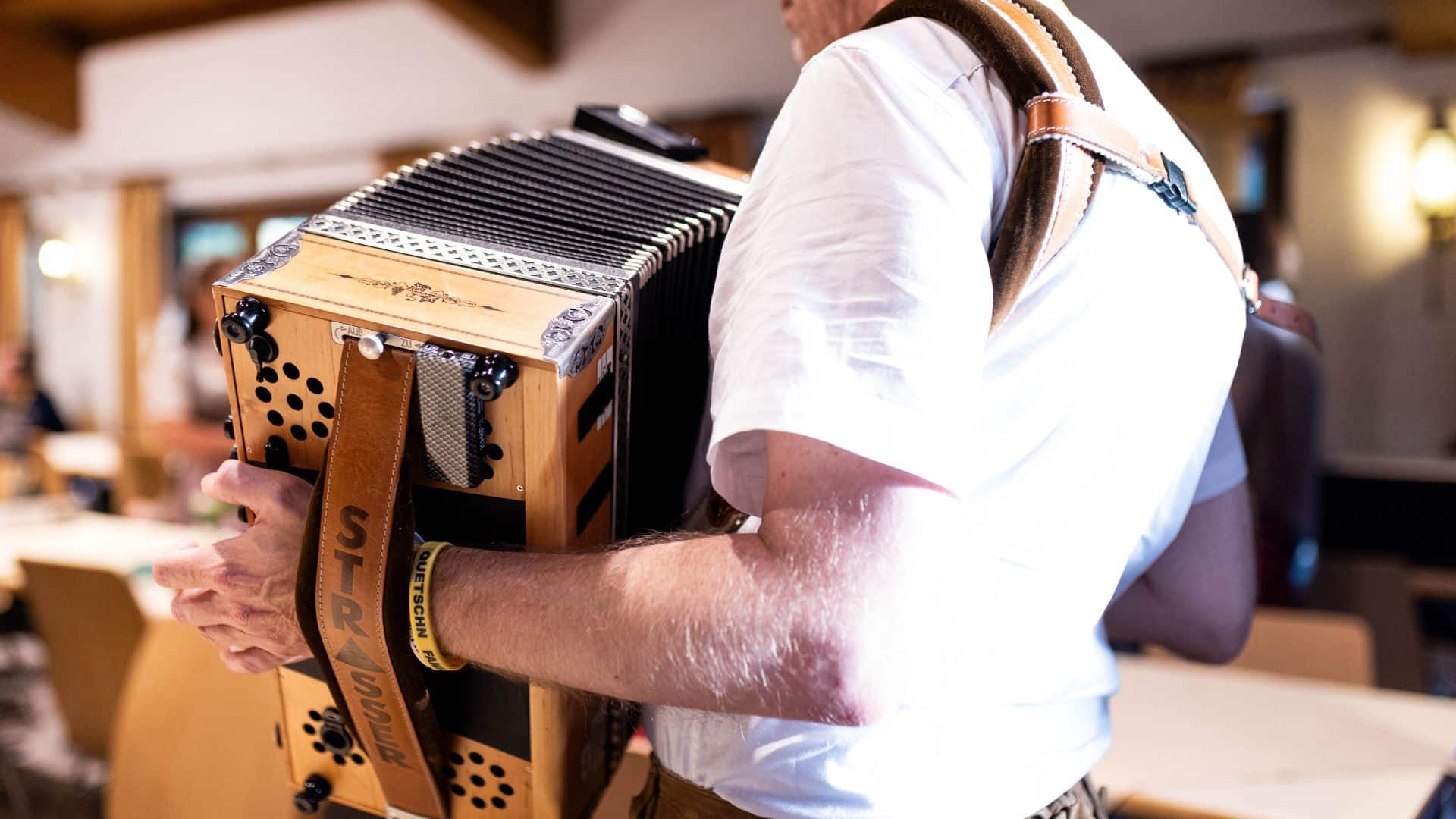 Ein Mann legt sich die Trageriemen einer Steirischen Harmonika um – Motivation und Startschuss für den Harmonika-Wiedereinstieg